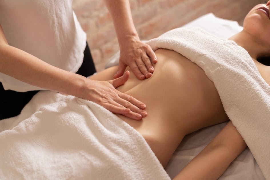 Femme allonger sur le dos durant un massage de la ceinture abdominale
